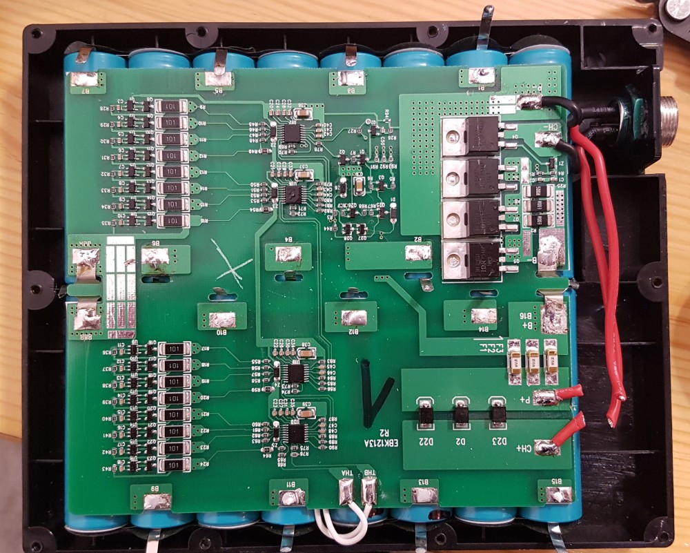 A partially unsoldered battery pack. Marked with an &lsquo;X&rsquo; to not reuse the board.